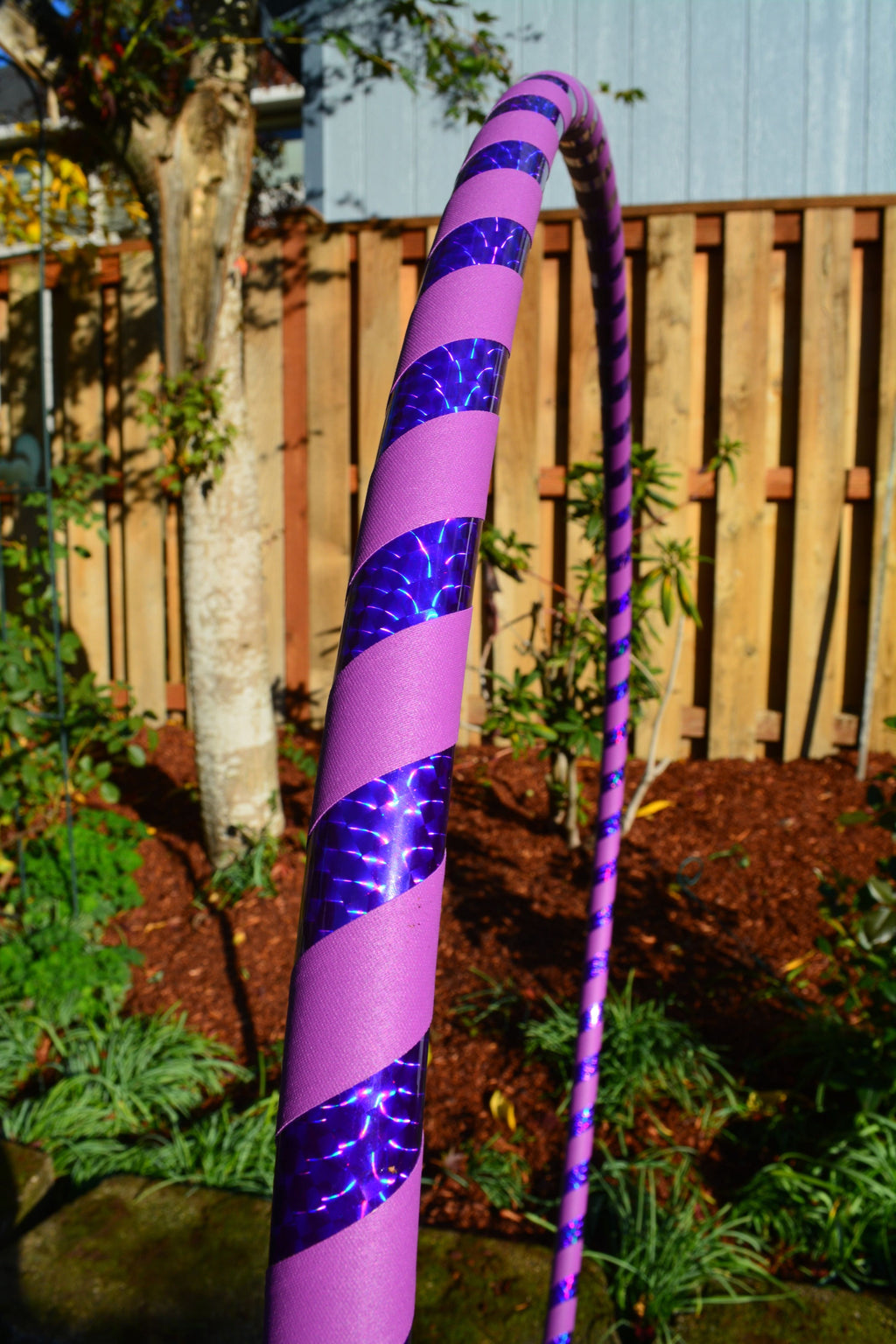 Purple weighted hula hoop with holographic tape and metallic accents on the tube