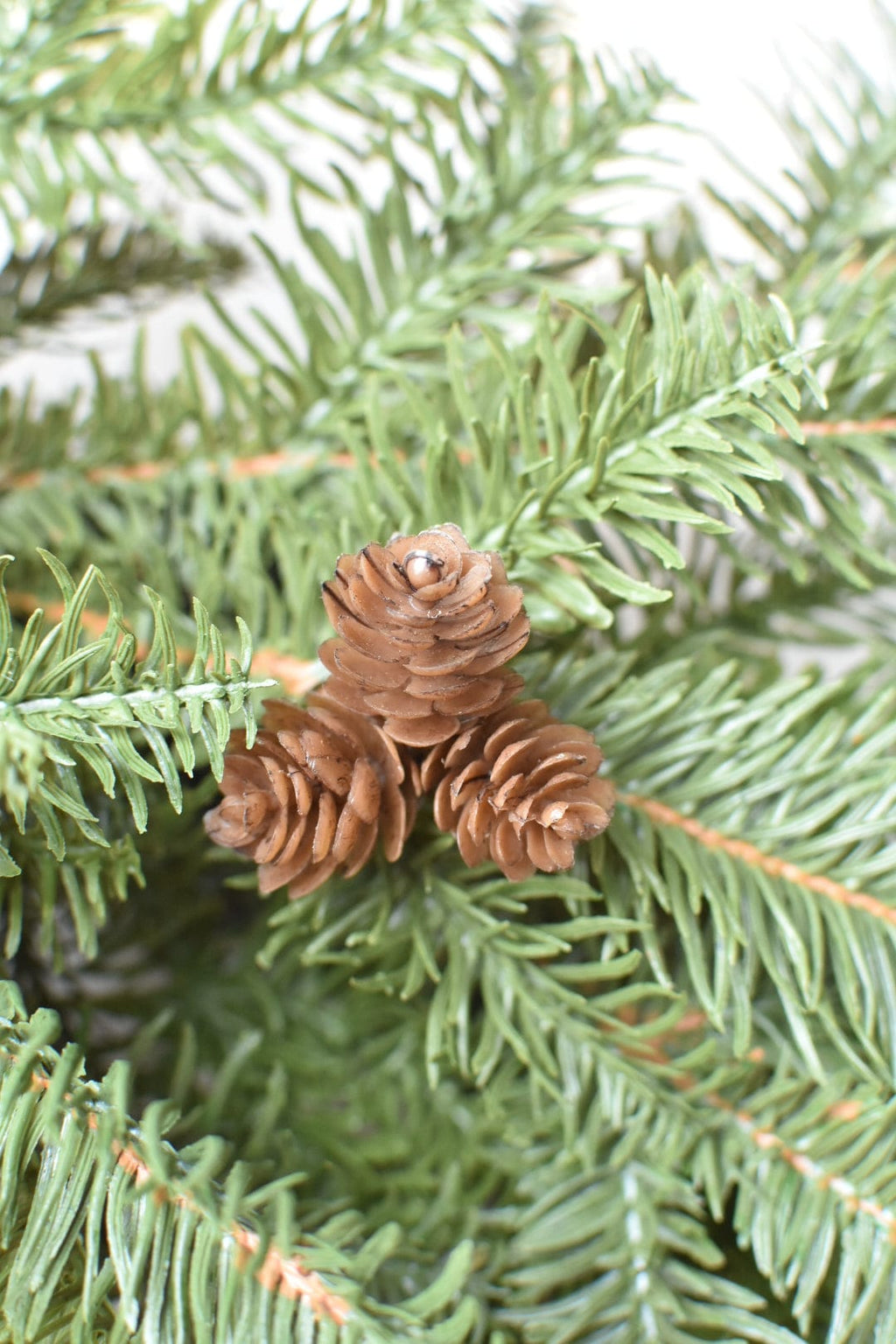 Faux pinecones nestled in green faux spruce branches