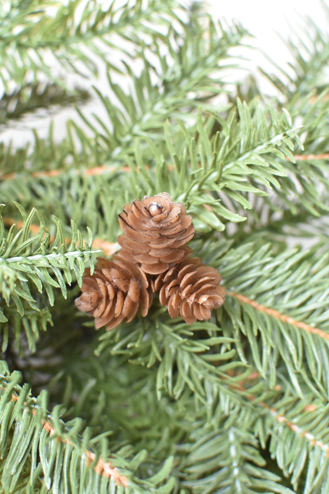 Faux pinecones nestled in green faux spruce branches