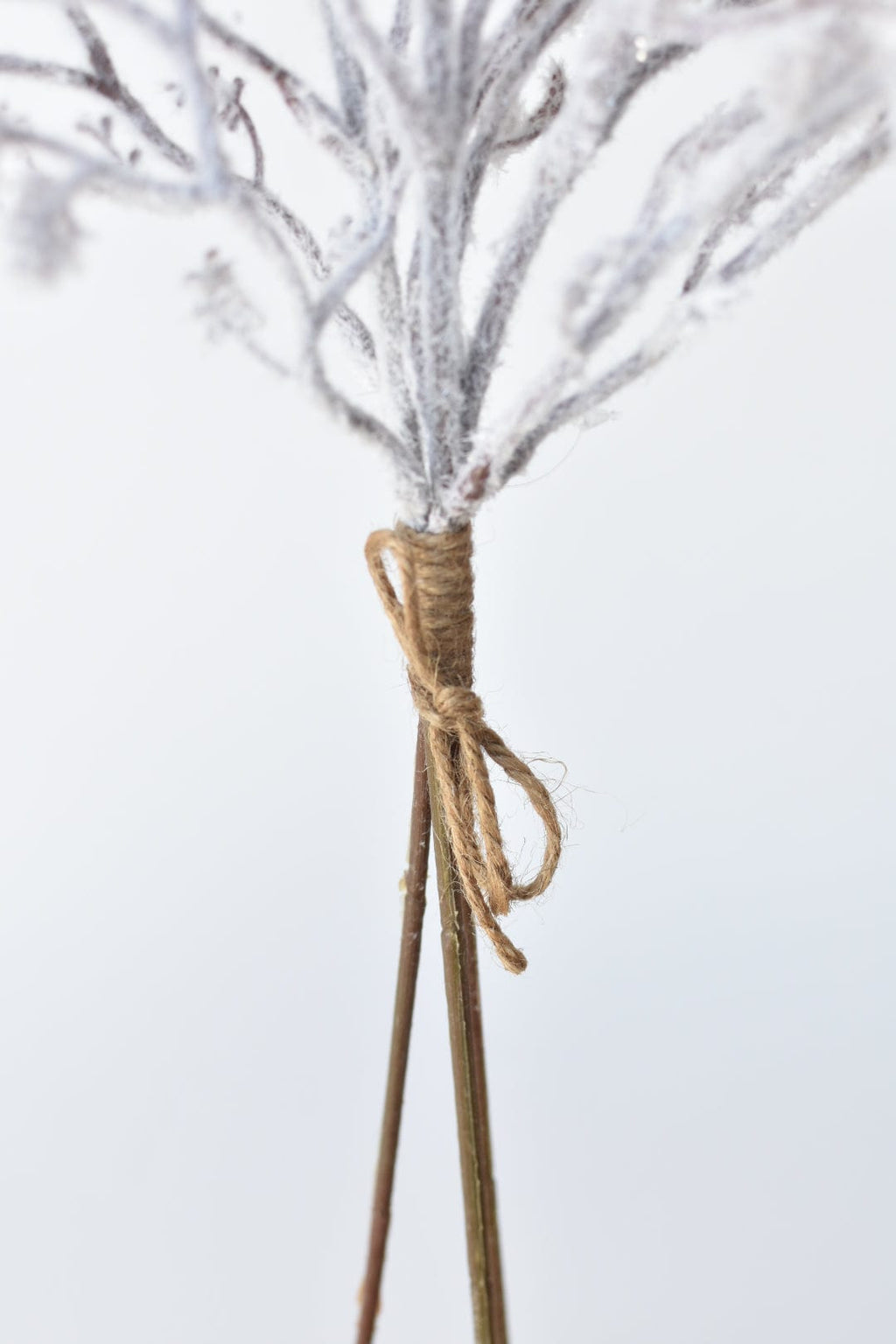 Faux flocked twig bundle with twine-tied base and three frosted twig stems