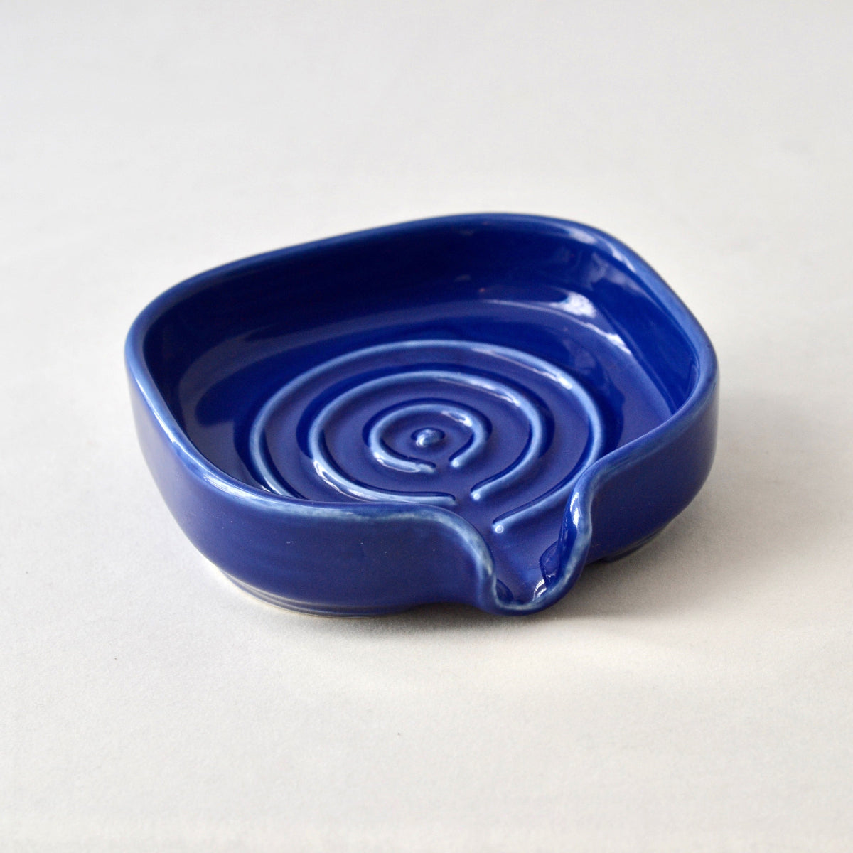 Cobalt blue porcelain self-draining soapdish with side spout and swirl well