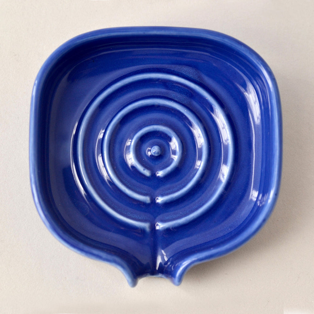 Top view of cobalt blue porcelain self-draining soapdish with circular drain detail