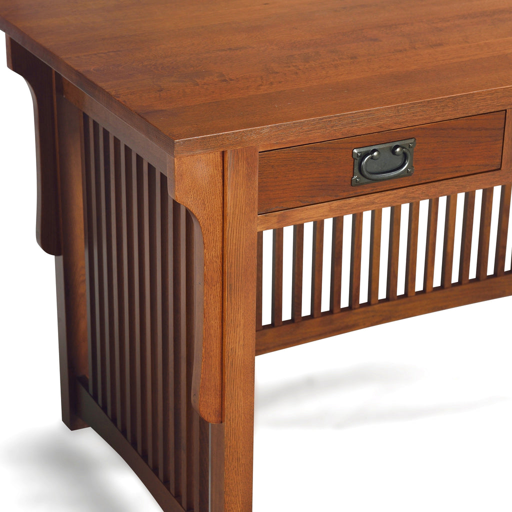Close-up of wood library desk corner with drawer and slatted side paneling in warm brown.