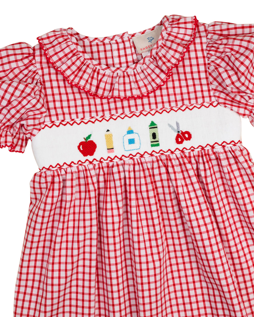 Red windowpane dress with embroidered village panel, smocked yoke, and ruffle trim
