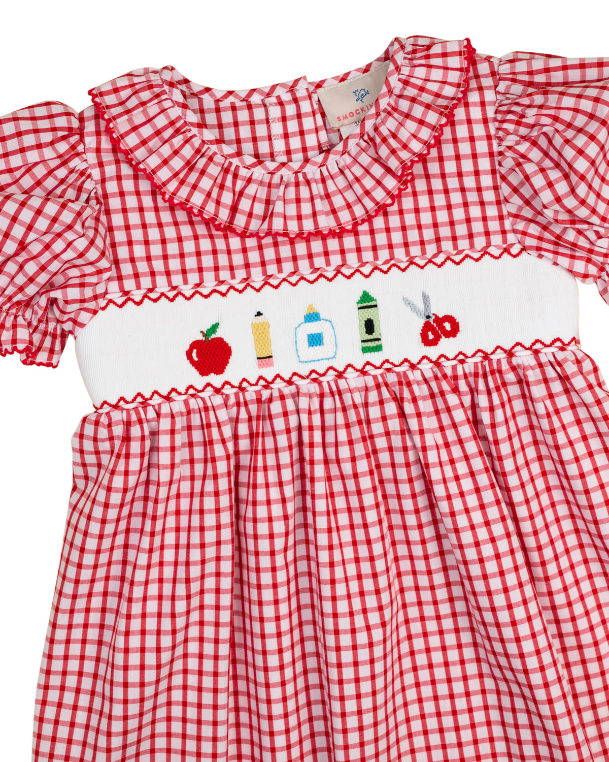 Red windowpane dress with embroidered village panel, smocked yoke, and ruffle trim
