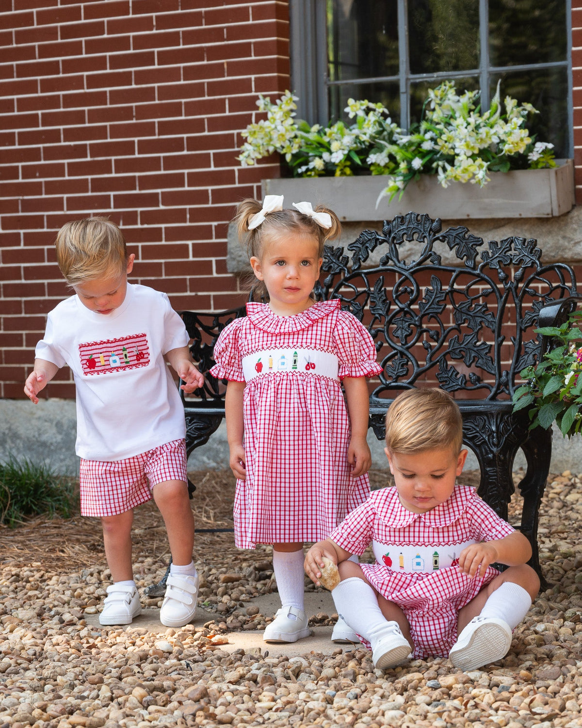 Red plaid smocked dress with embroidered house panel, puff sleeves, and ruffled collar
