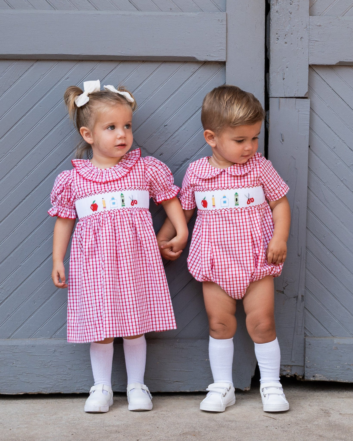 Red-and-white plaid smocked dress with embroidered house panel and ruffled neckline