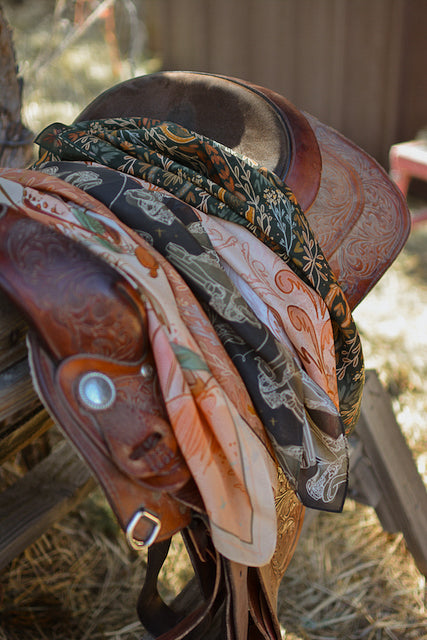 Dusty rose wild rag scarf with paisley and botanical pattern, tied on saddle horn