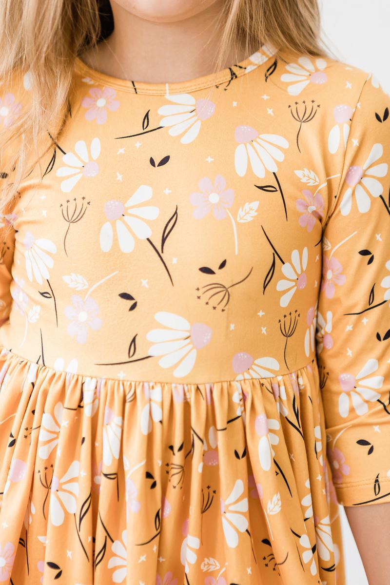 Girls orange floral twirl dress close-up with gathered neckline and 3/4 sleeves