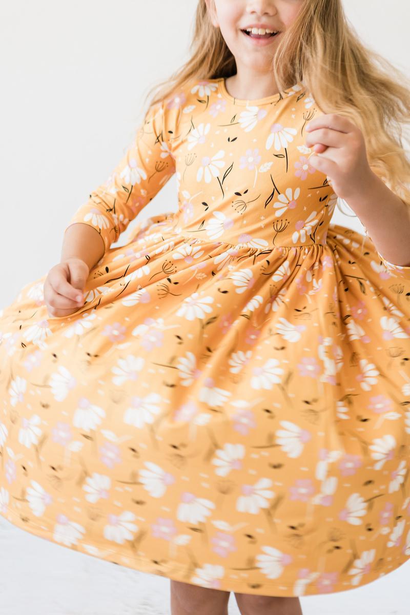 Girls orange floral twirl dress with round neckline and puffed gathered skirt