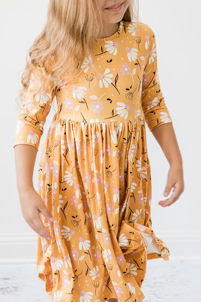 Girls orange floral twirl dress front view with gathered waist and 3/4 sleeves