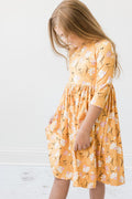 Girls 3/4 sleeve twirl dress in orange with white floral print and gathered skirt