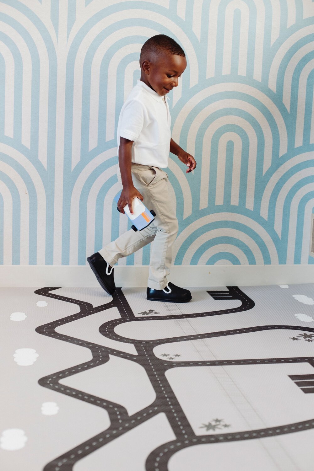 Kids' easy-on barefoot shoes, black slip-on with white trim on white pants