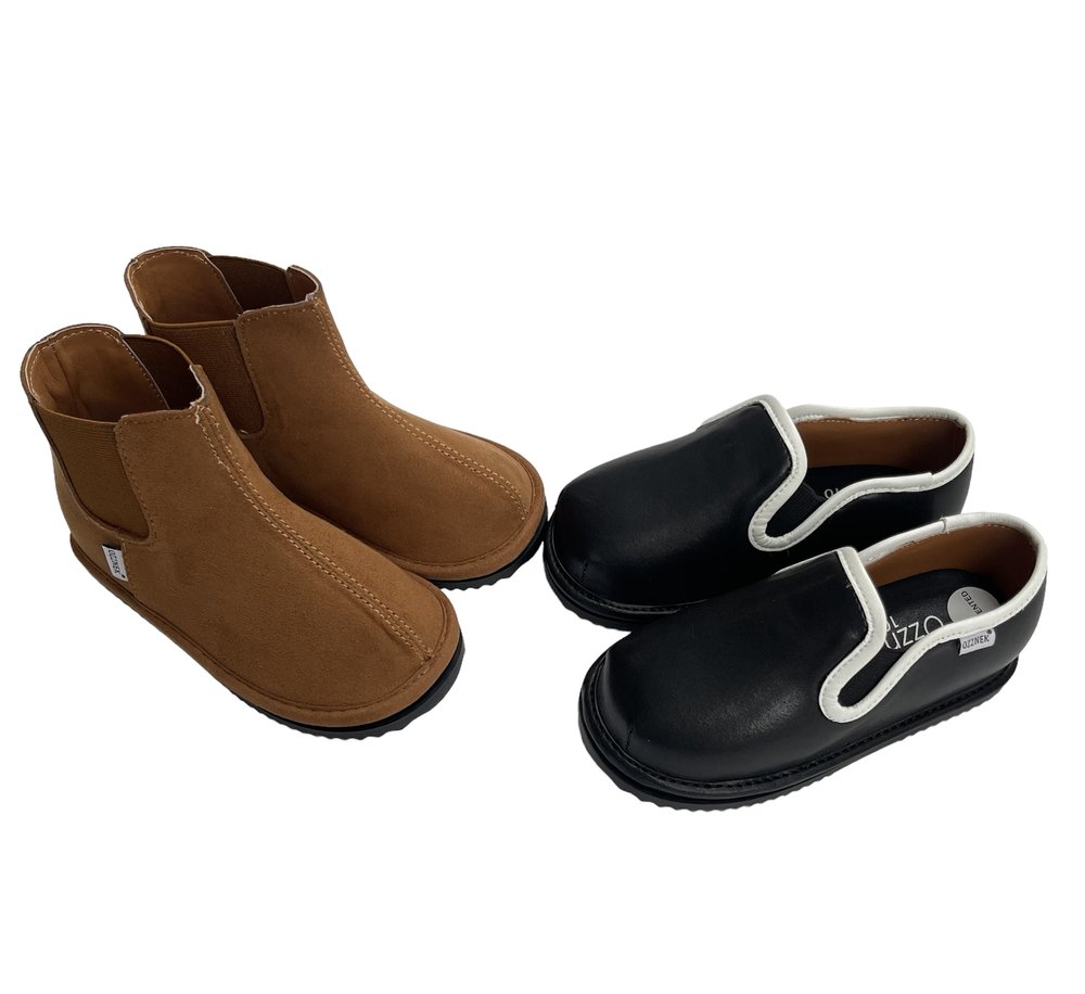 Two pairs of kids' easy-on barefoot shoes: tan brown and black slip-ons
