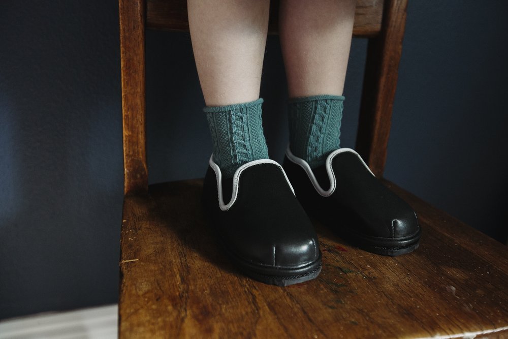Kids' easy-on barefoot shoes with teal socks, black slip-on with white trim