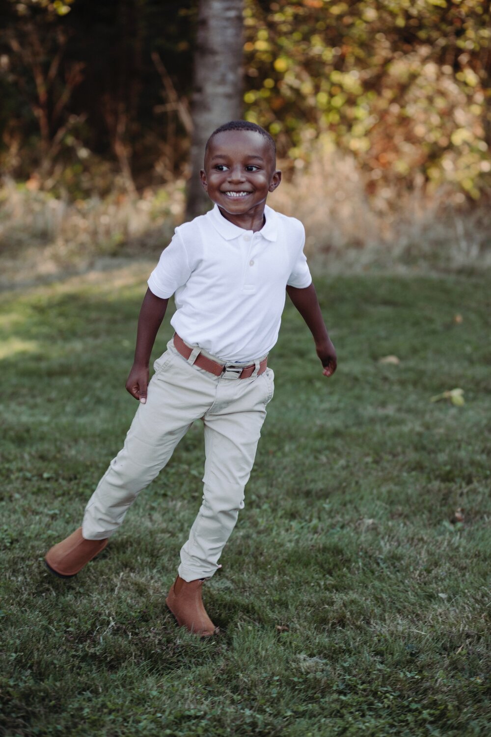 Tan slip-on barefoot kids' shoes with low profile, worn by child.