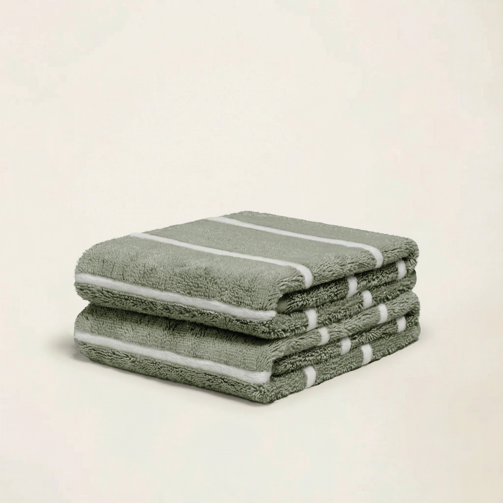 Sage green cotton towels stack with terry texture and white stripe accents