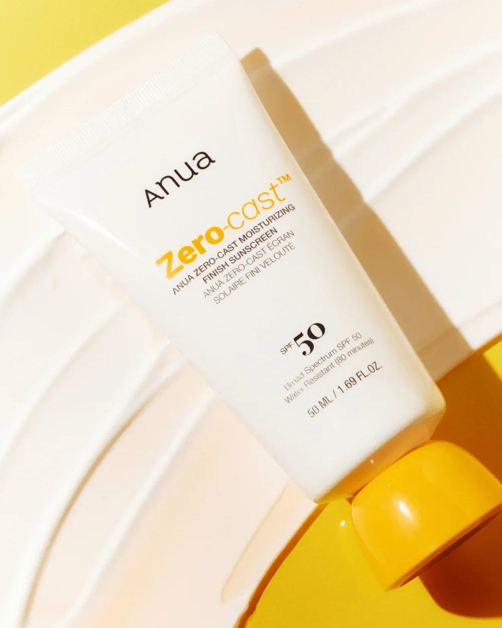 Anua Zero-cast SPF 50+ sunscreen tube angled view, white tube with orange cap