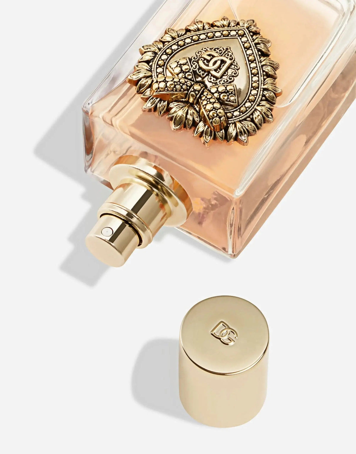 Perfume bottle sprayer and gold cap with pink liquid, Dolce & Gabbana Devotion