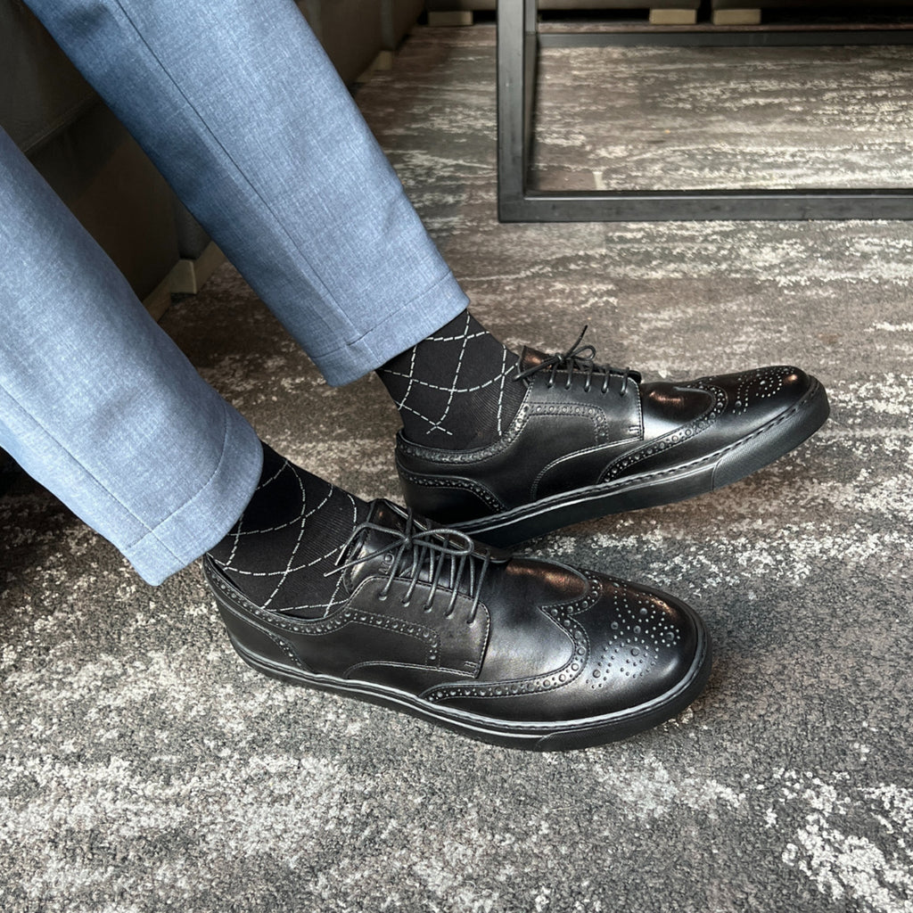 Black wingtip lace-up dress shoes with patterned overlays and laces
