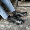 Black wingtip lace-up dress shoes with patterned overlays and laces