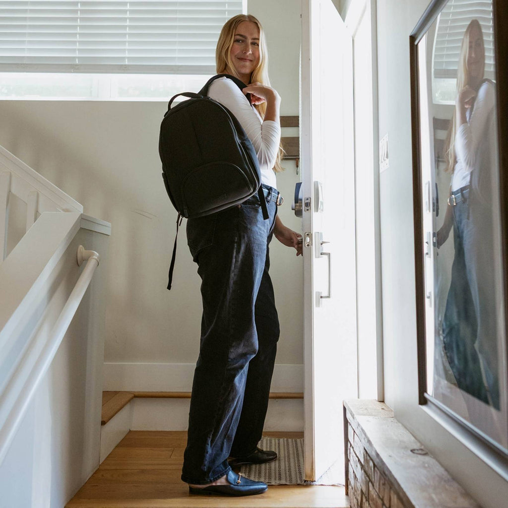Black diaper backpack carried at side with large round back panel