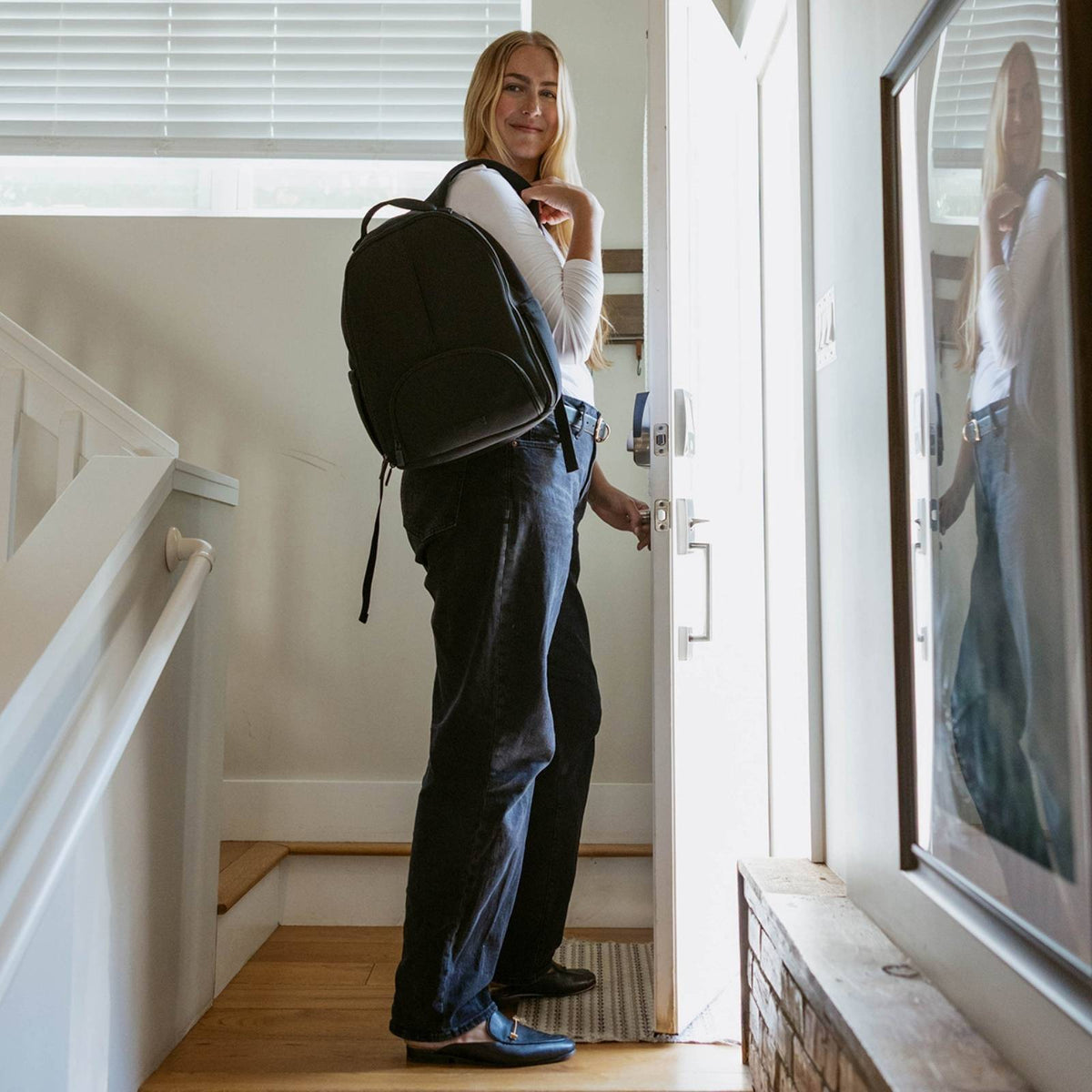 Black diaper backpack carried at side with large round back panel