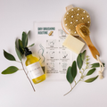 Body care kit with wooden dry brush, yellow body oil, soap bar, loofah pouch