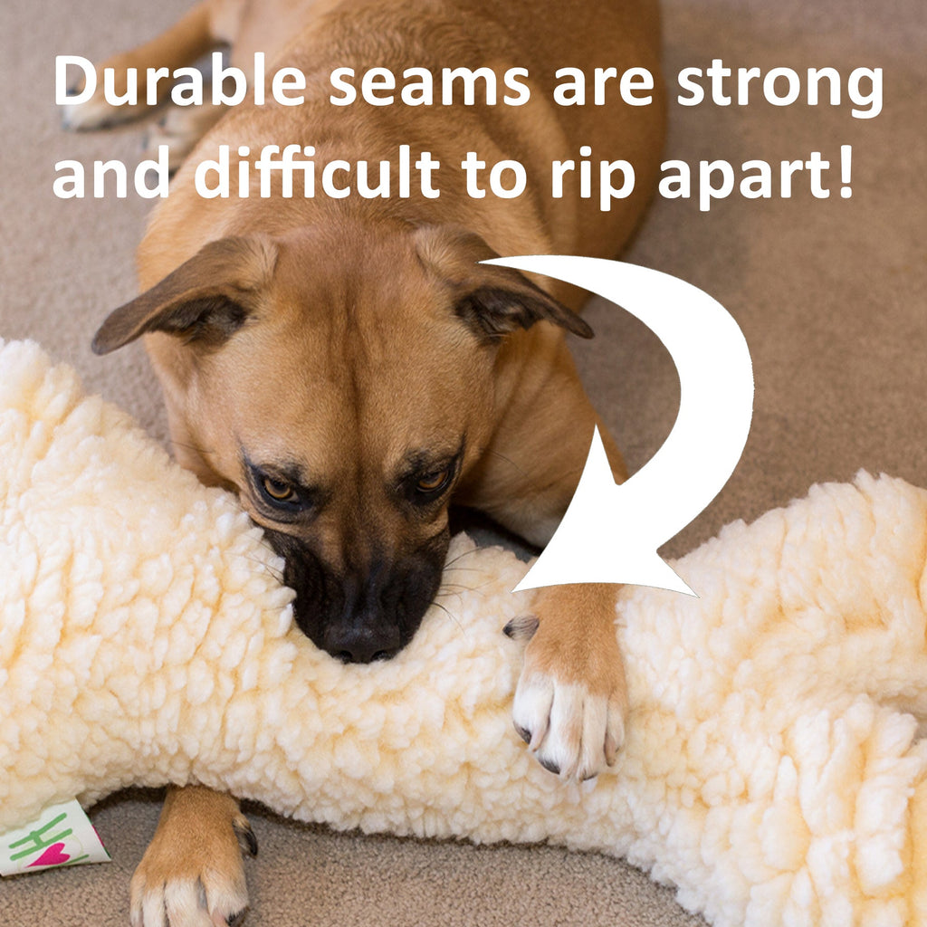 Cream plush ball dog toy partially wrapped around a dog on a couch