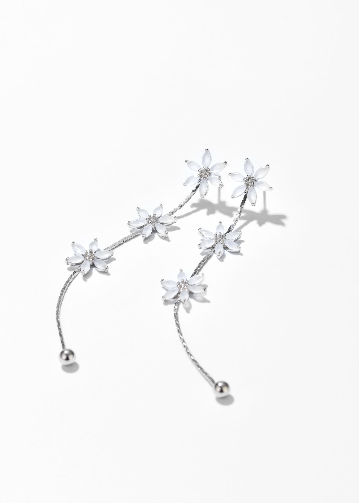 Silver sakura flower drop earrings with multiple dangling blossoms and curved chain