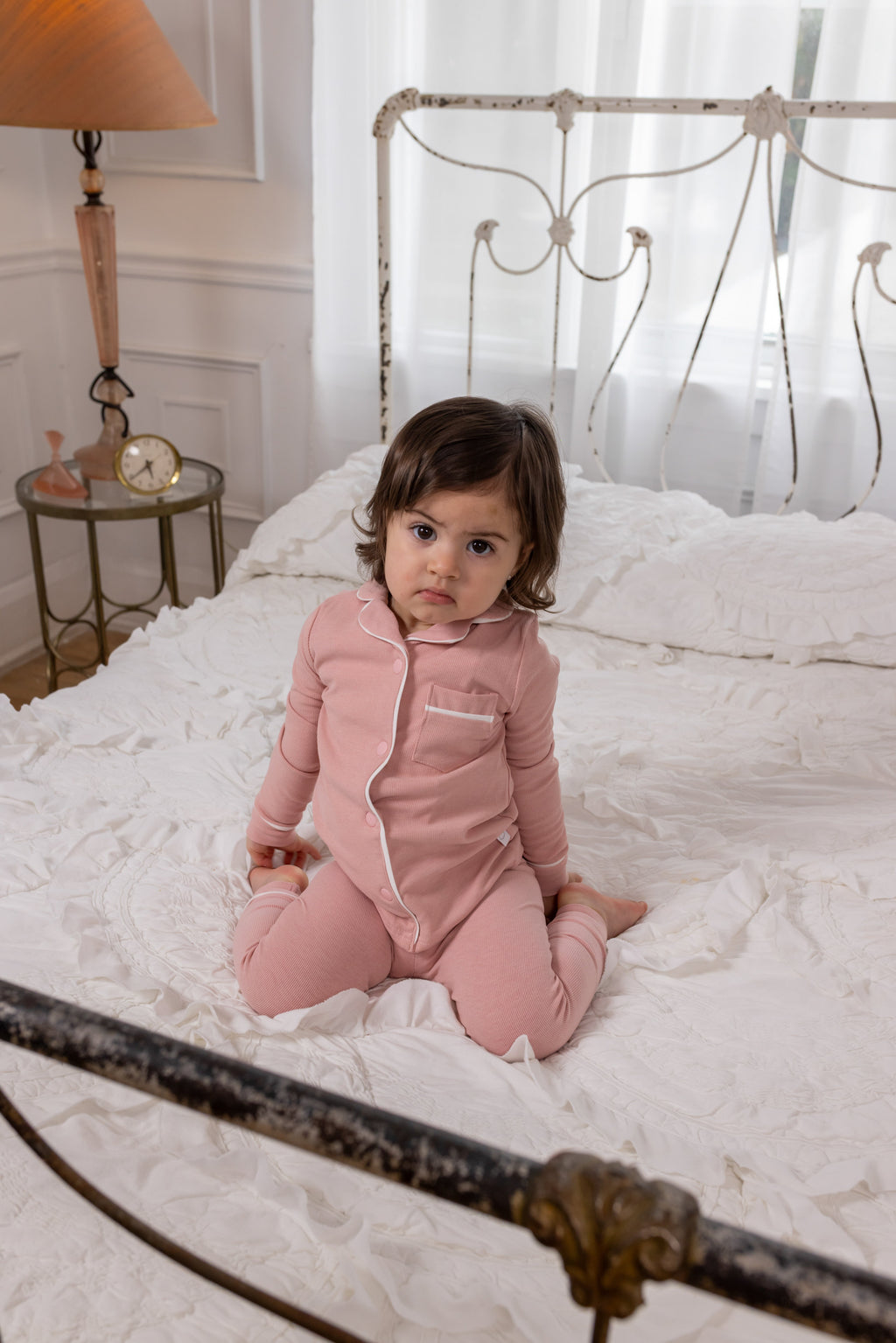 Pink long-sleeve pajama top with button placket and matching pants on child