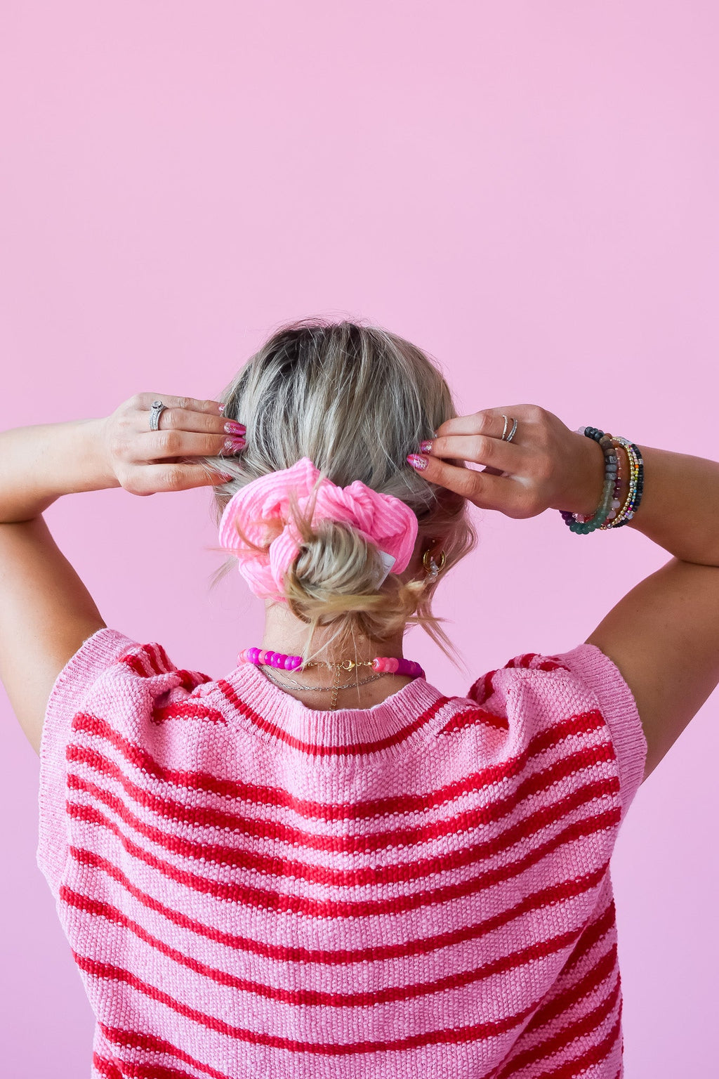 Pink ribbed scrunchy holding a ponytail bun