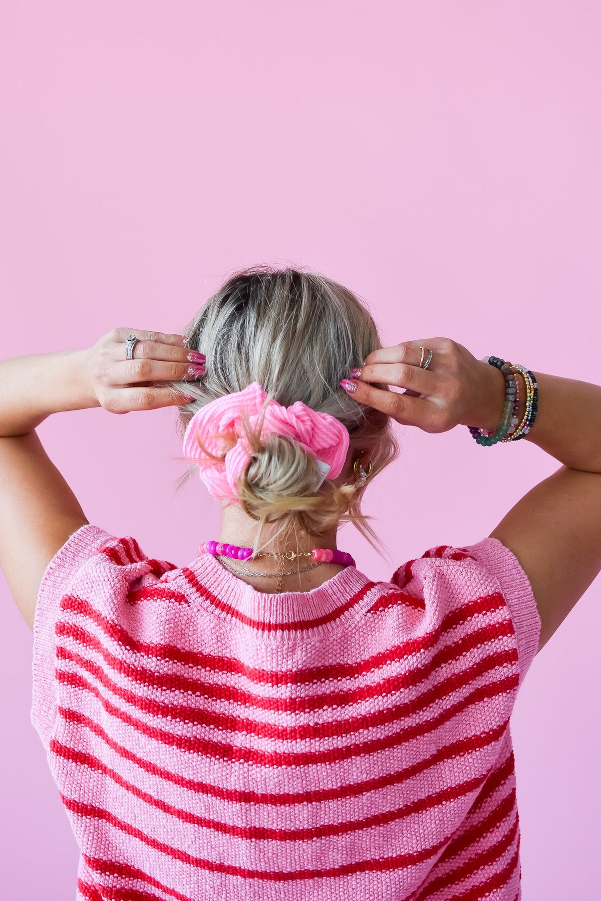 Pink ribbed scrunchy holding a ponytail bun