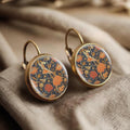 Round floral earrings with orange and blue pattern, bronze leverback hooks.