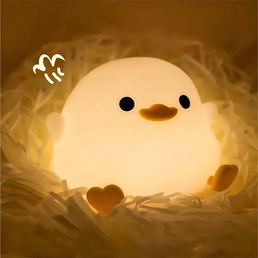 Duck silicone night light with warm glow, round body, and heart-shaped feet