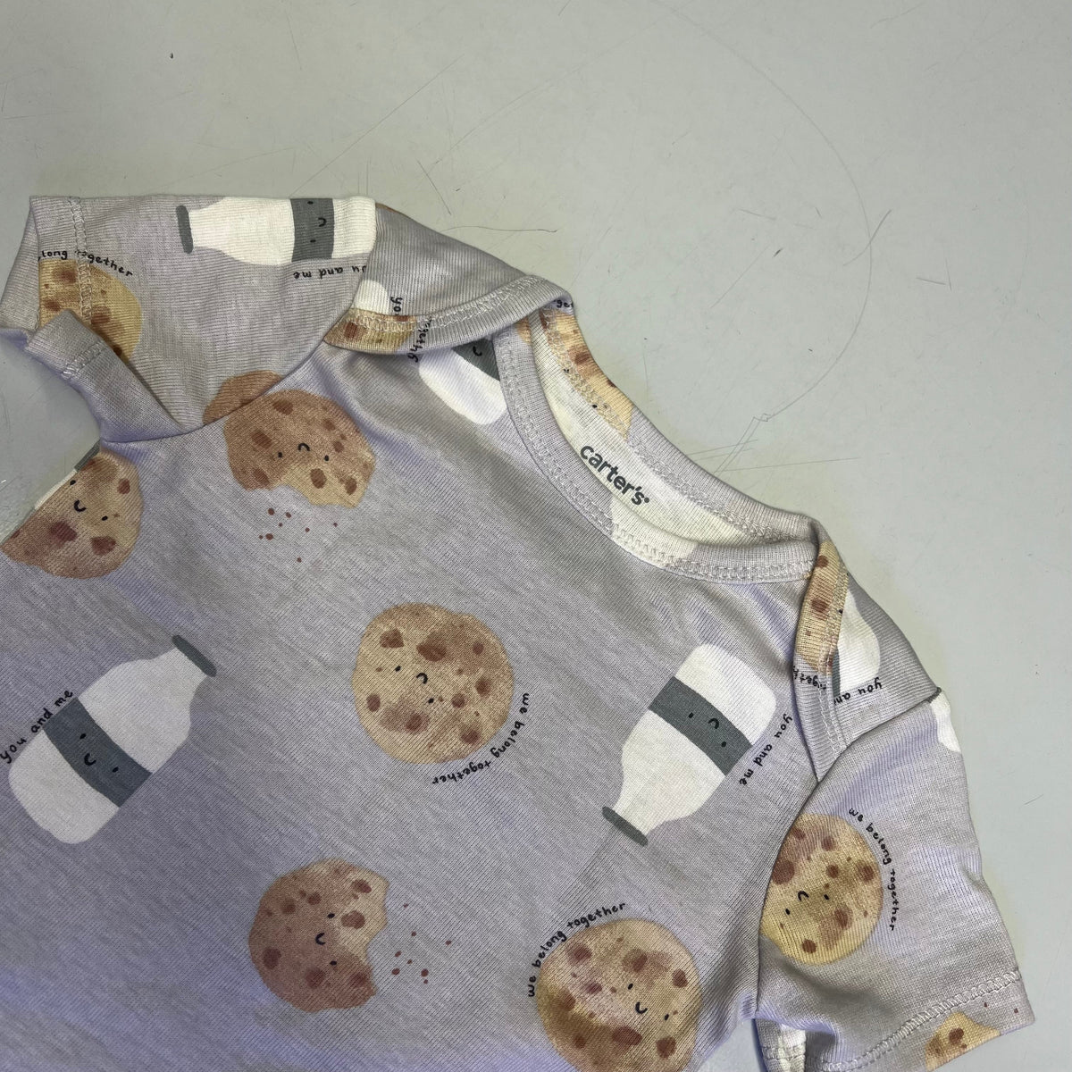 Baby cotton cookie-print bodysuit close-up at neckline and sleeve cuffs