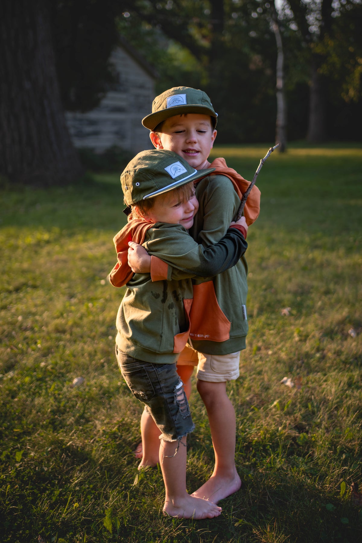 Kids green zip hoodie with orange hood and front panel, white drawcords