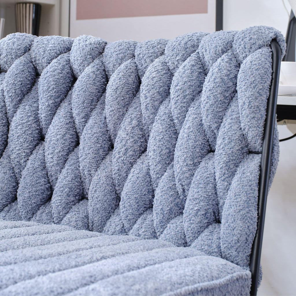 Blue tufted fabric backrest of armless desk chair with black frame edges