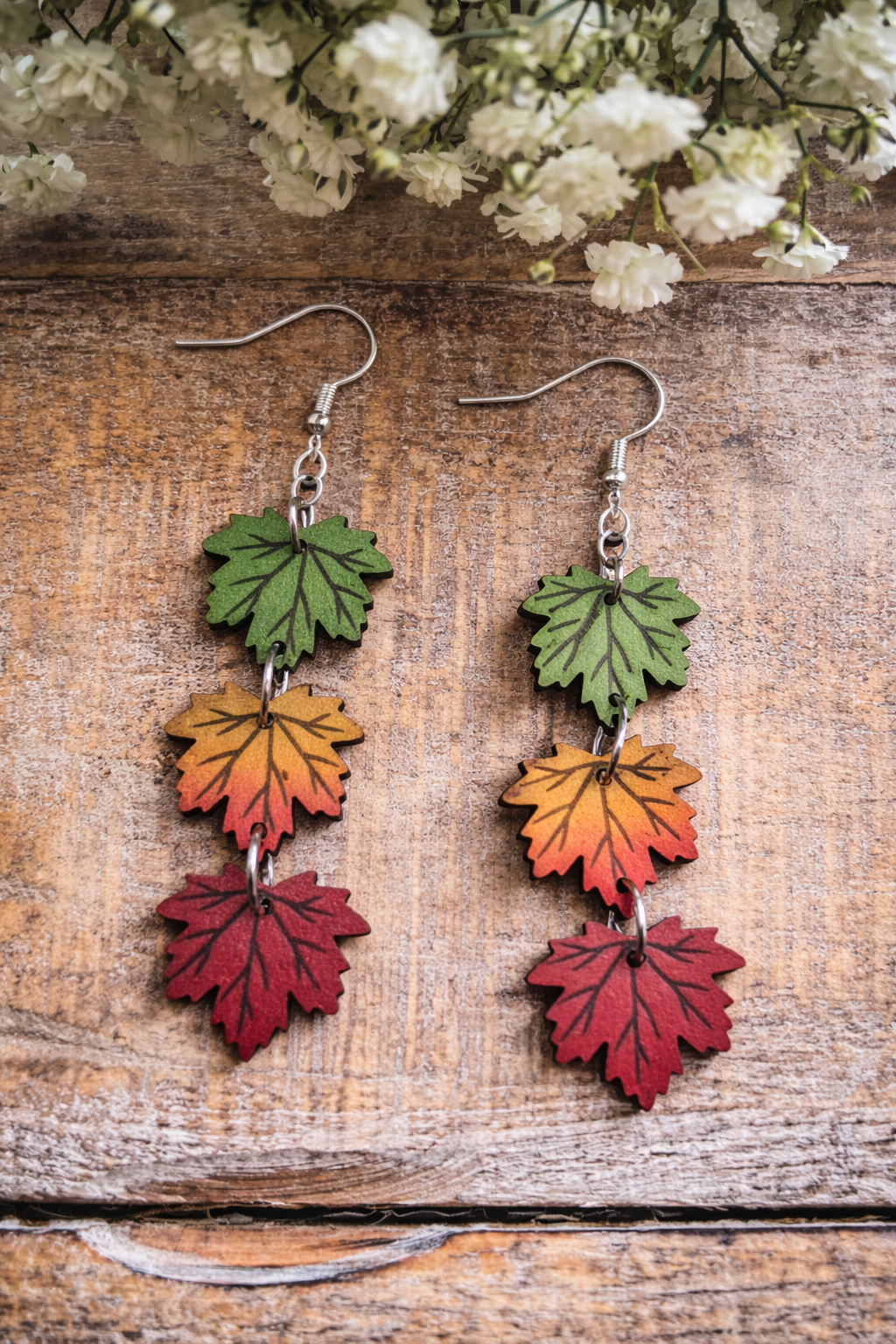 Dangling fall leaf earrings with green, orange and red leaf charms on silver hooks