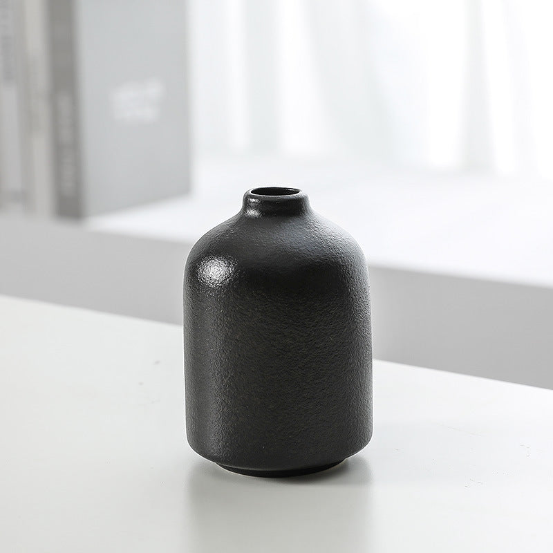 Black ceramic vase bottle with rounded shoulders and small circular opening