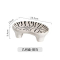 Ceramic decorative plate with zebra stripe pattern, curved paw shape