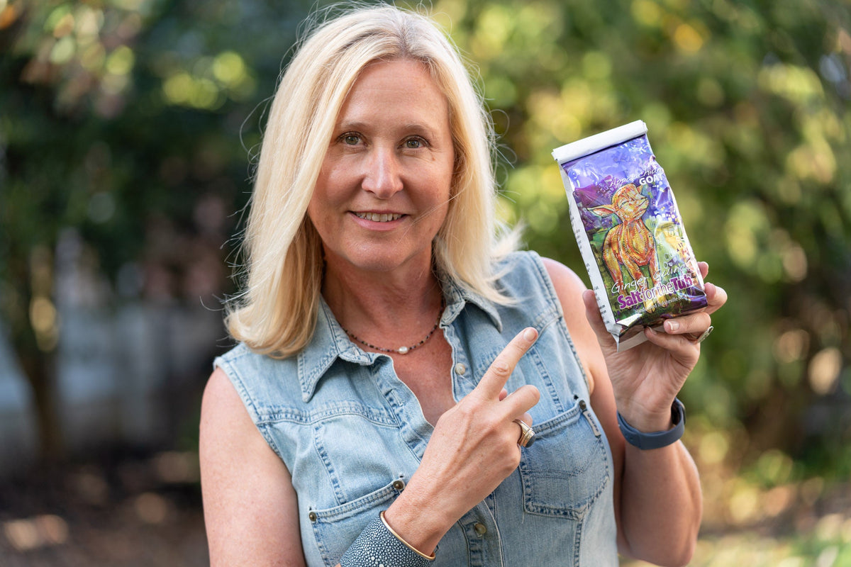 Bath salt pouch in hand with purple goat graphic label