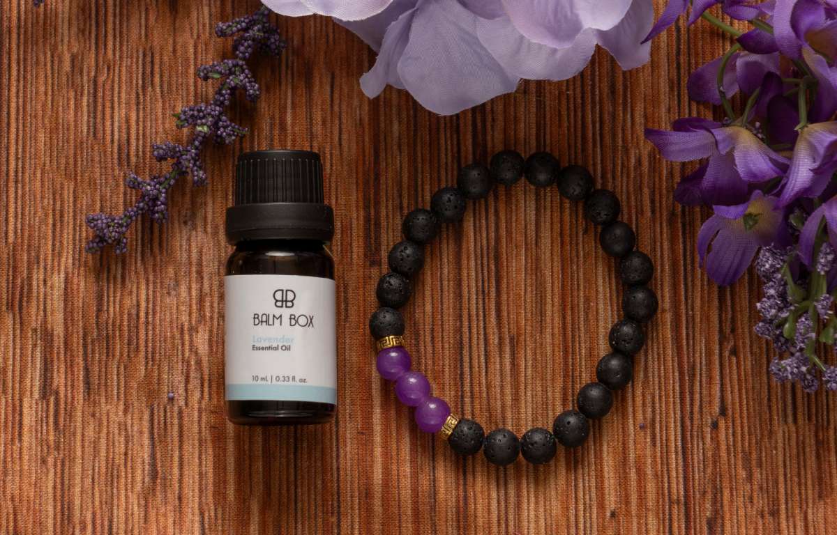 Botanical balm bottle with beaded bracelet and purple flowers