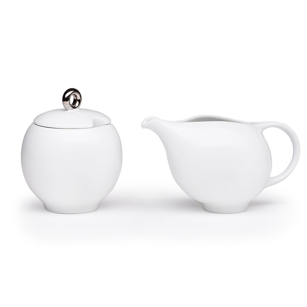 White ceramic sugar bowl with lid and matching creamer, rounded spout and handle