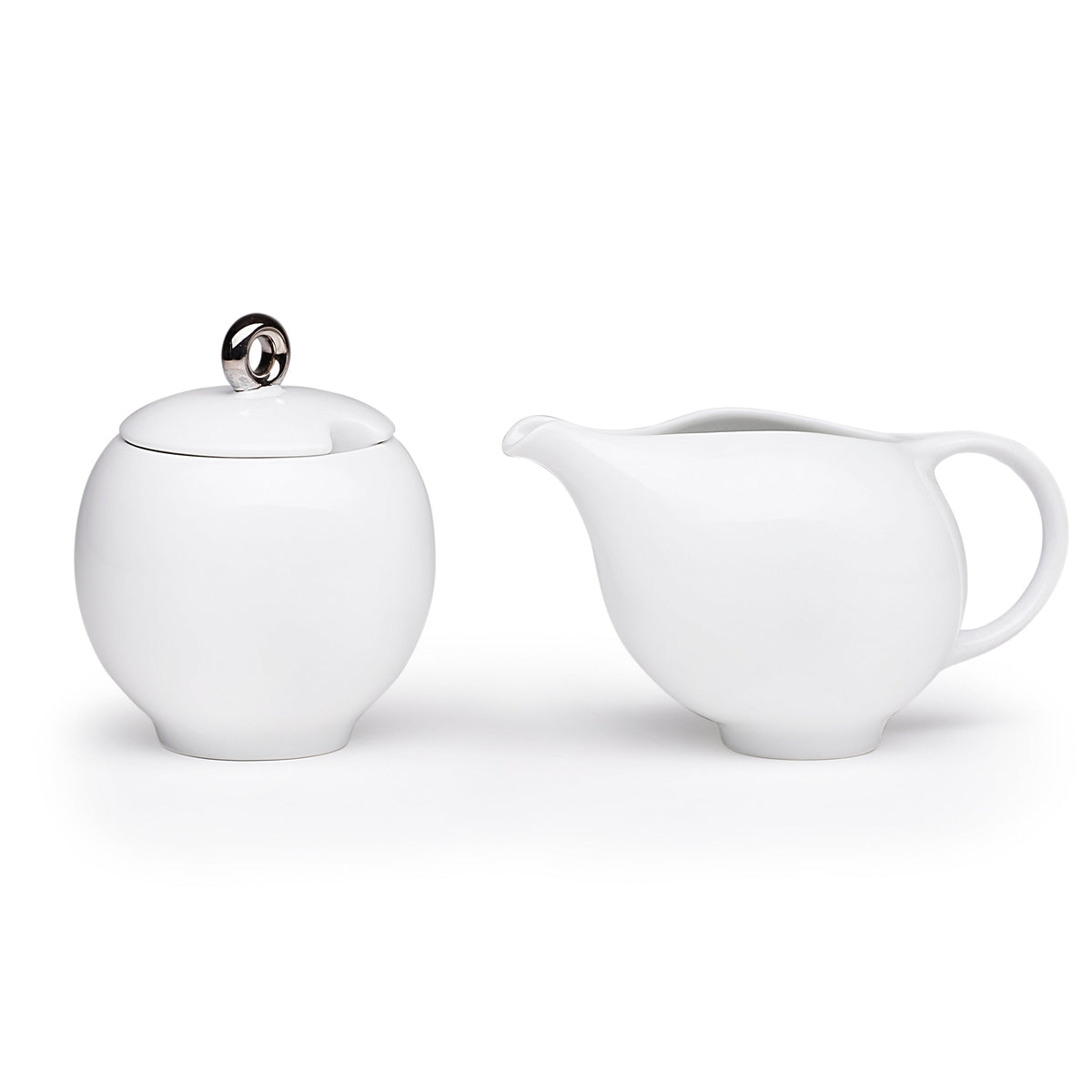 White ceramic sugar bowl with lid and matching creamer, rounded spout and handle