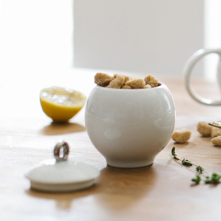 White ceramic sugar bowl with lid, spoon set inside