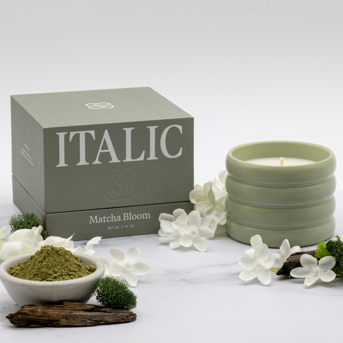 Ceramic soy candle with lit wick in sage green, Matcha Bloom scent, with gift box.