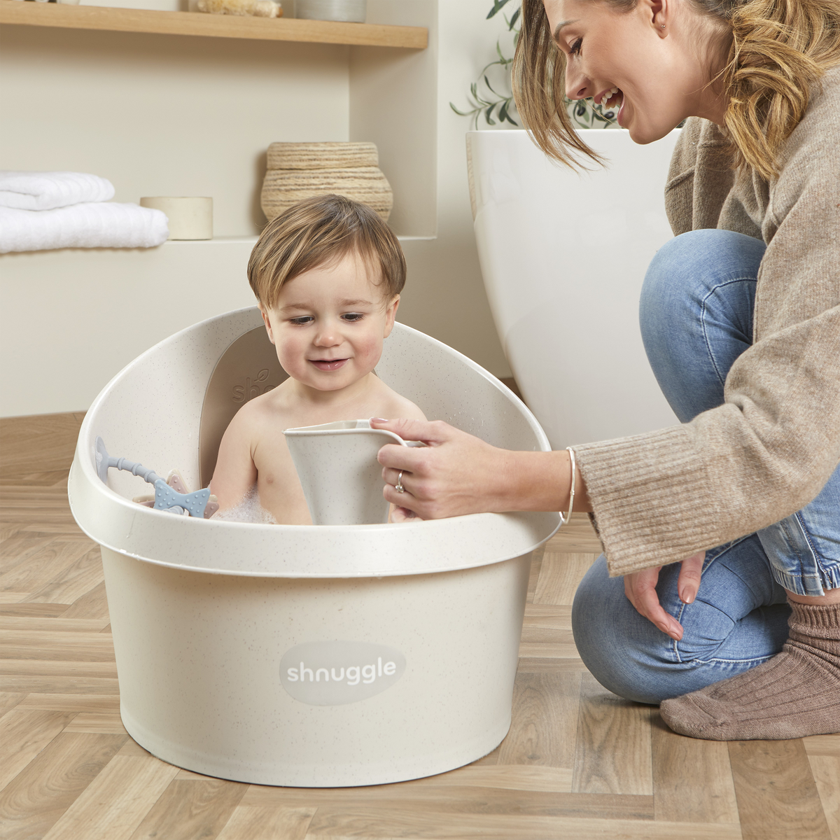 Toddler bath tub with child seated, backrest insert visible