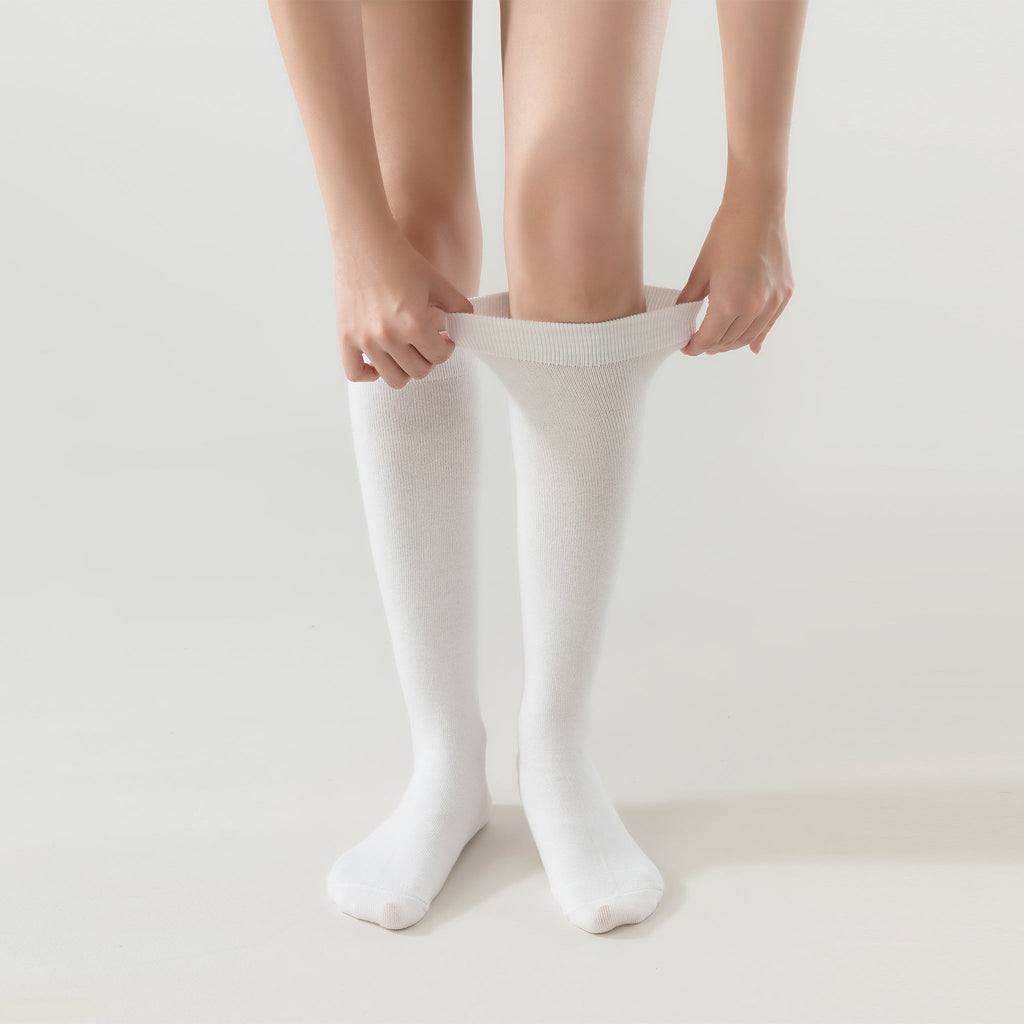 Cream white crew socks being pulled on, ribbed cuff visible
