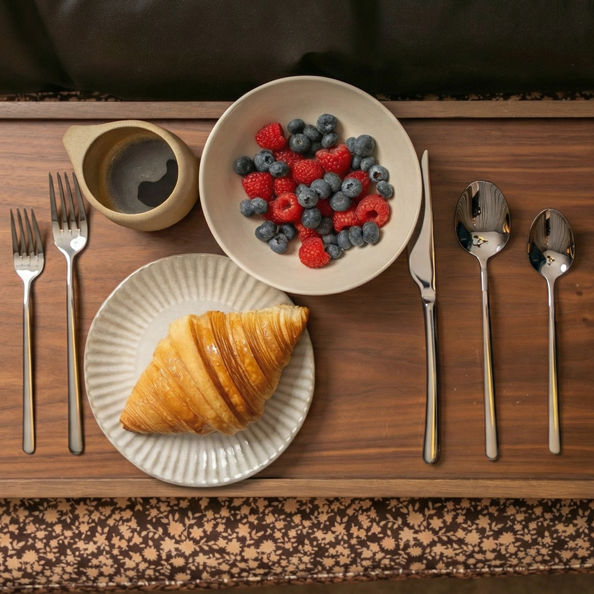 Silver flatware set with spoon and fork for meal service on wooden tray